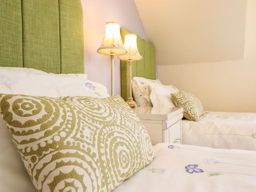 A bedroom with two beds and lamps at Llwyn Derw in Talybont