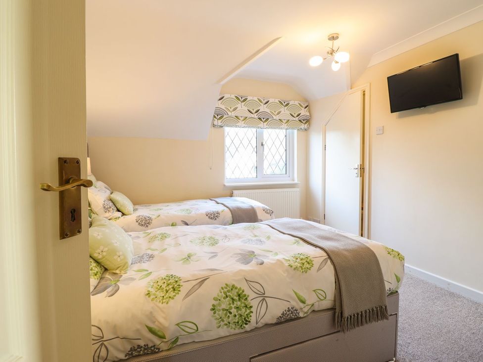 A bedroom with two beds and a television at Llwyn Derw in Talybont