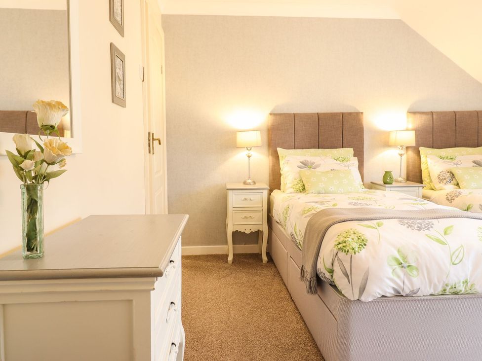 A bedroom with two beds and a dresser at Llwyn Derw Talybont