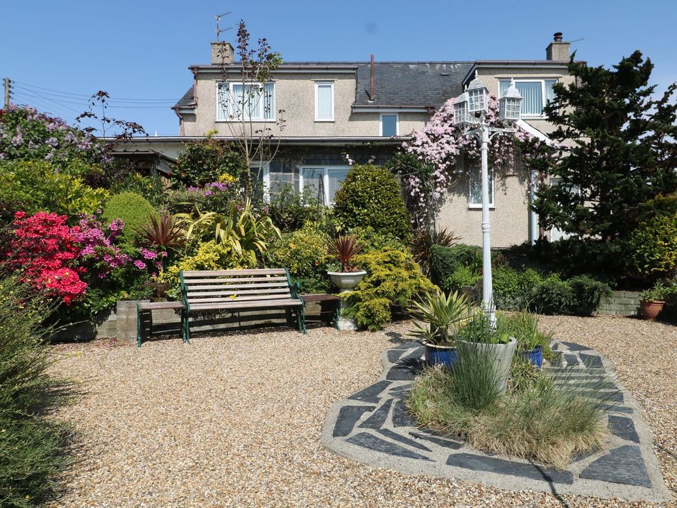 A garden with flowers and a bench at Llwyn Derw Talybont