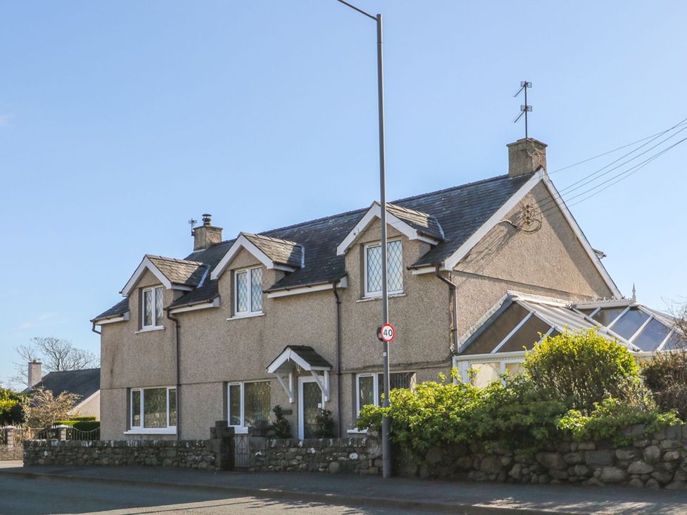 A house with windows and a conservatory at Llwyn Derw in Talybont