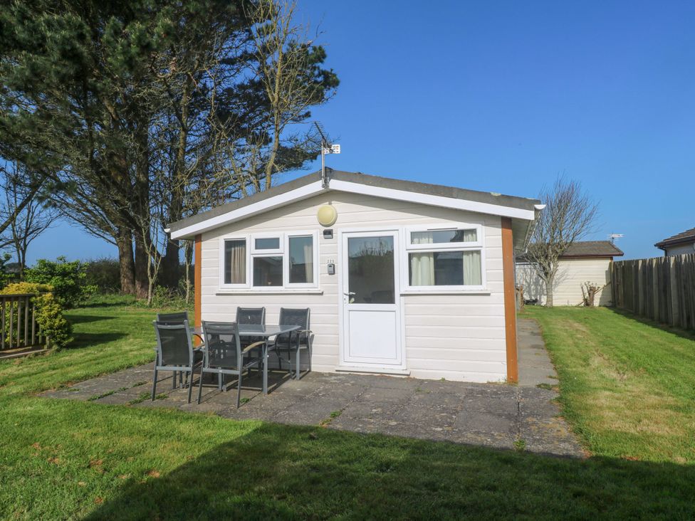 A chalet with a patio and seating area at Chalet 225 Tregolds near St Merryn