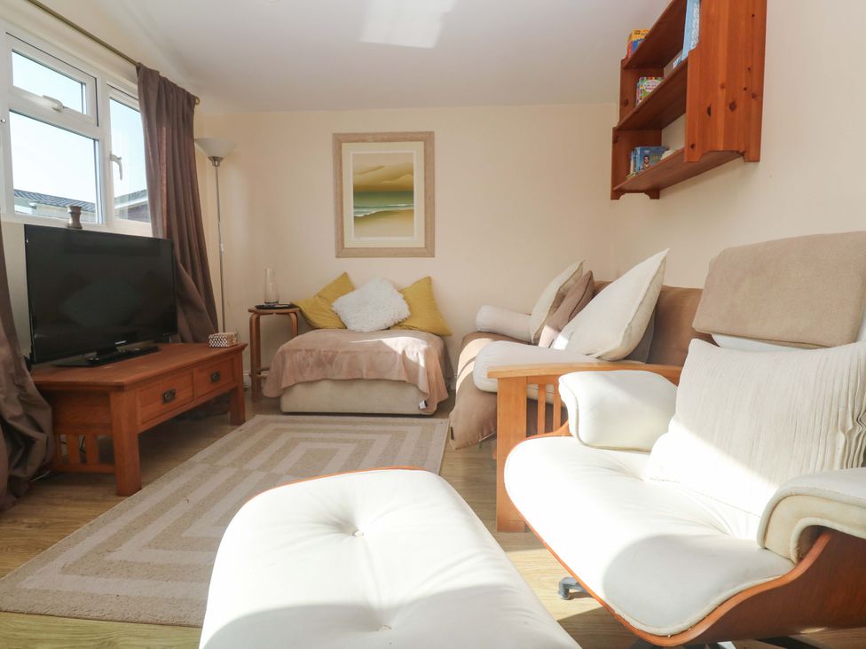 A living room with a television and sofa at Chalet 225 Tregolds near St Merryn