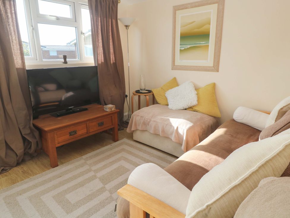 A living room with a television and sofa at Chalet 225 Tregolds near St Merryn