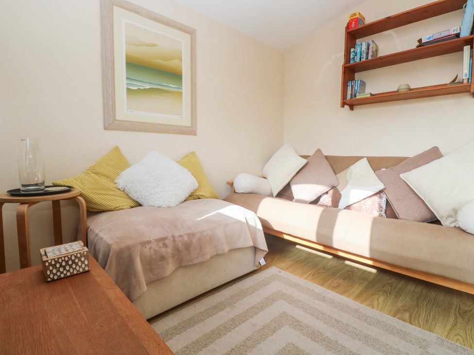 A snug with a sofa and wall art at Chalet 225 in Tregolds near St Merryn