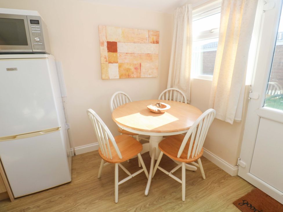 A dining room with a table and chairs at Chalet 225 Tregolds near St Merryn