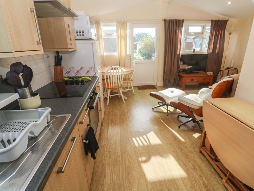 A kitchen with a dining area and television at Chalet 225 Tregolds near St Merryn