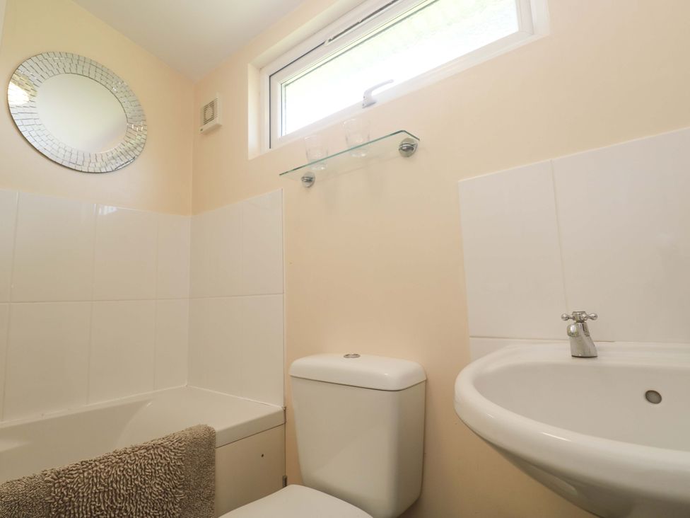 A bathroom with a bathtub sink and toilet at Chalet 225 Tregolds near St Merryn
