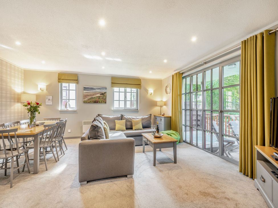 A living room with a sofa and dining area at Ailsa Craig Spa Dailly