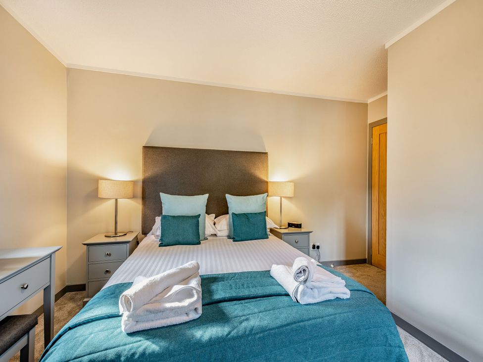 A bedroom with a bed and lamps at Ailsa Craig Spa Dailly