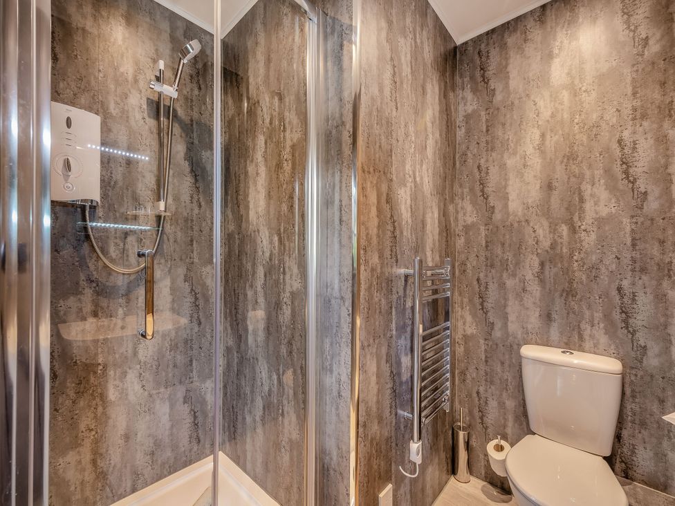 A bathroom with a shower and toilet at Ailsa Craig Spa in Dailly