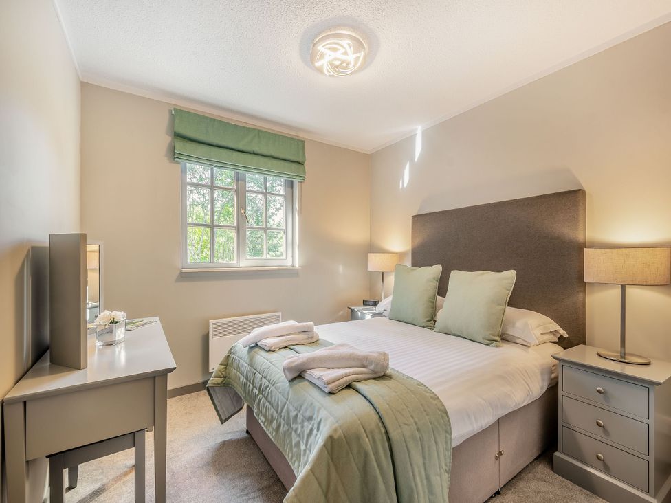 A bedroom with a bed and nightstand at Ailsa Craig Spa in Dailly