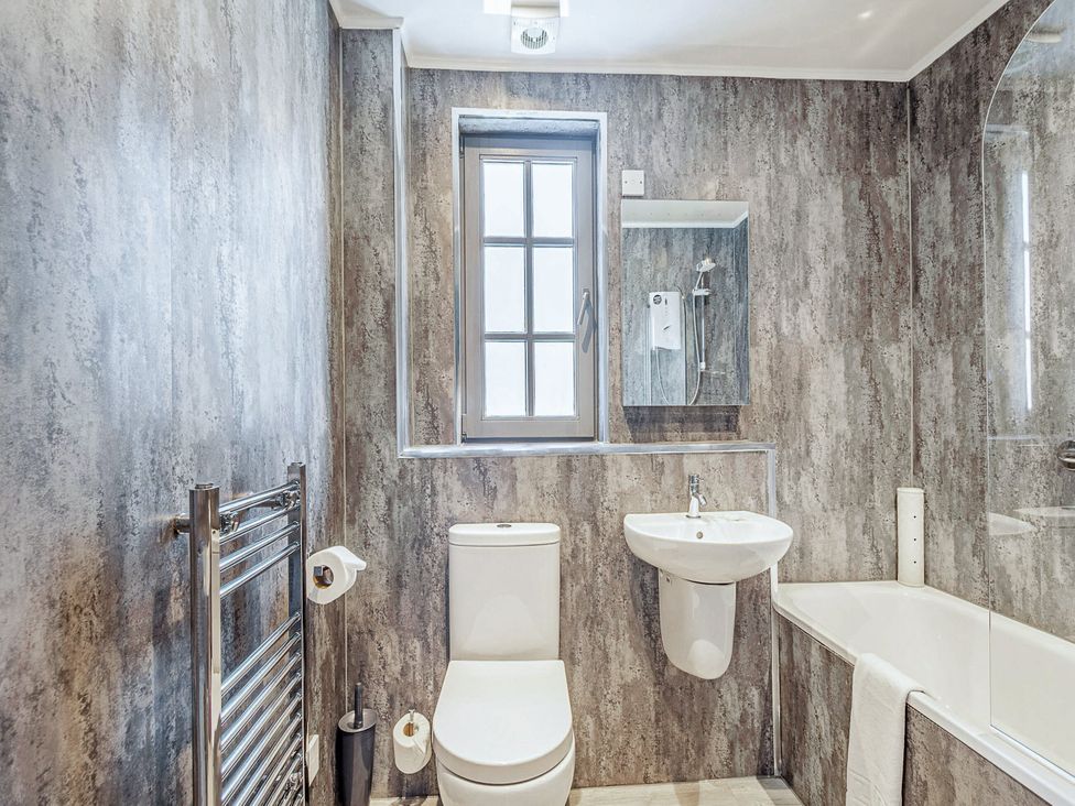A bathroom with a toilet, sink, bathtub, and window at Ailsa Craig Spa in Dailly