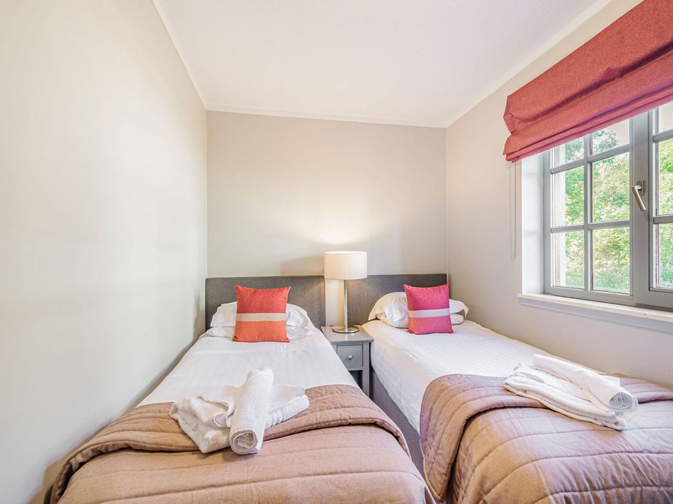 A bedroom with two single beds and a lamp at Ailsa Craig Spa, Dailly