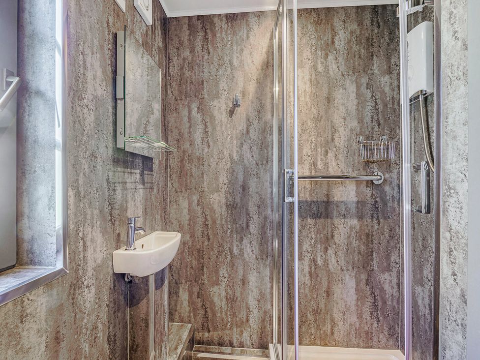 A bathroom with a shower and sink at Ailsa Craig Spa Dailly