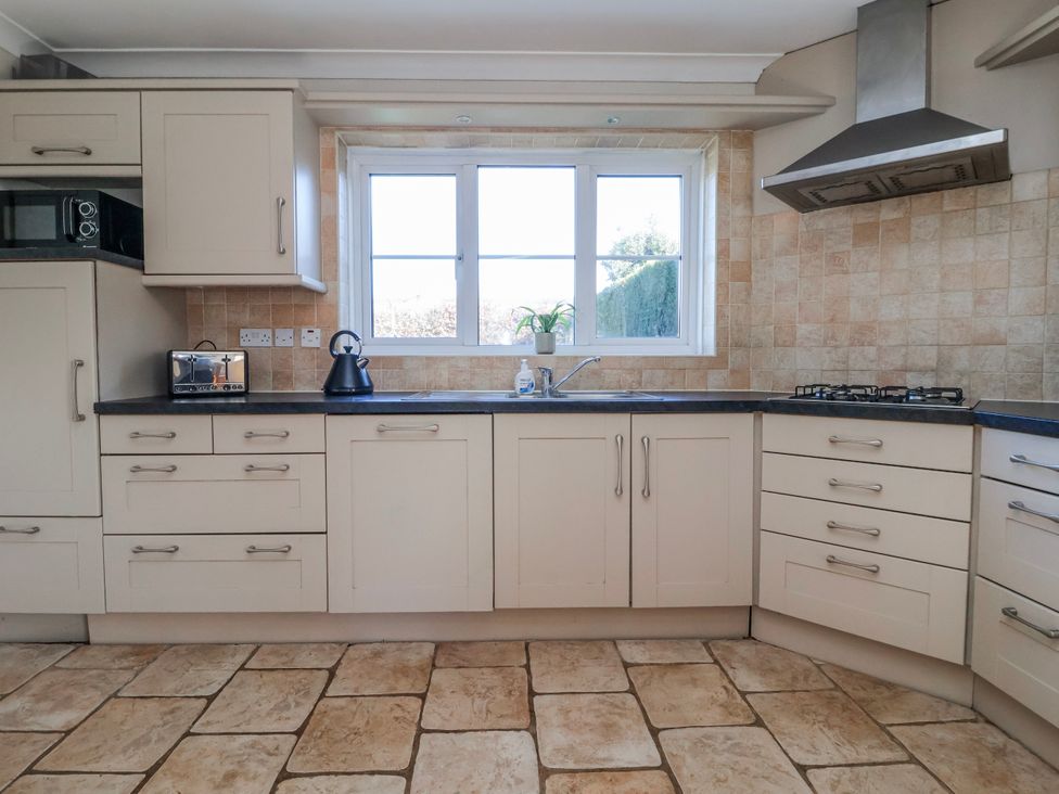 A kitchen with cabinets and appliances at Thorntons House in Morton-On-Swale