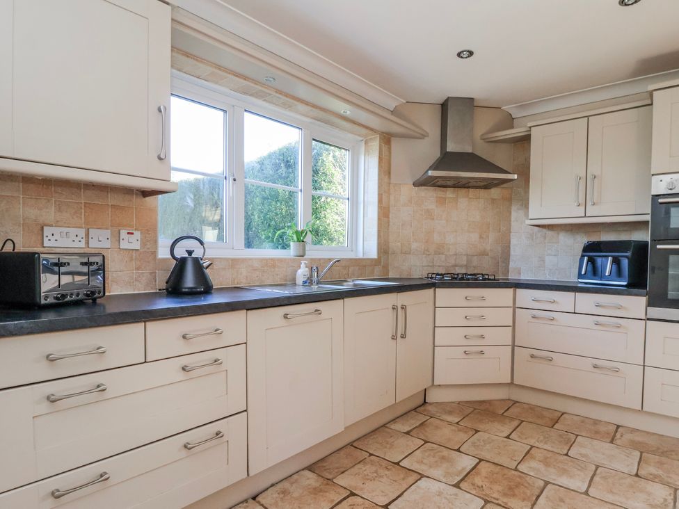 A kitchen with cabinets and appliances at Thorntons House in Morton-On-Swale