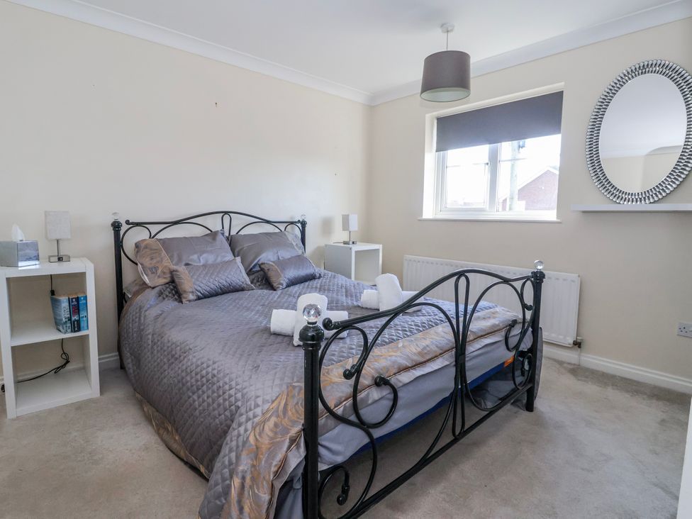 A bedroom with a bed and nightstands at Thorntons House in Morton-On-Swale