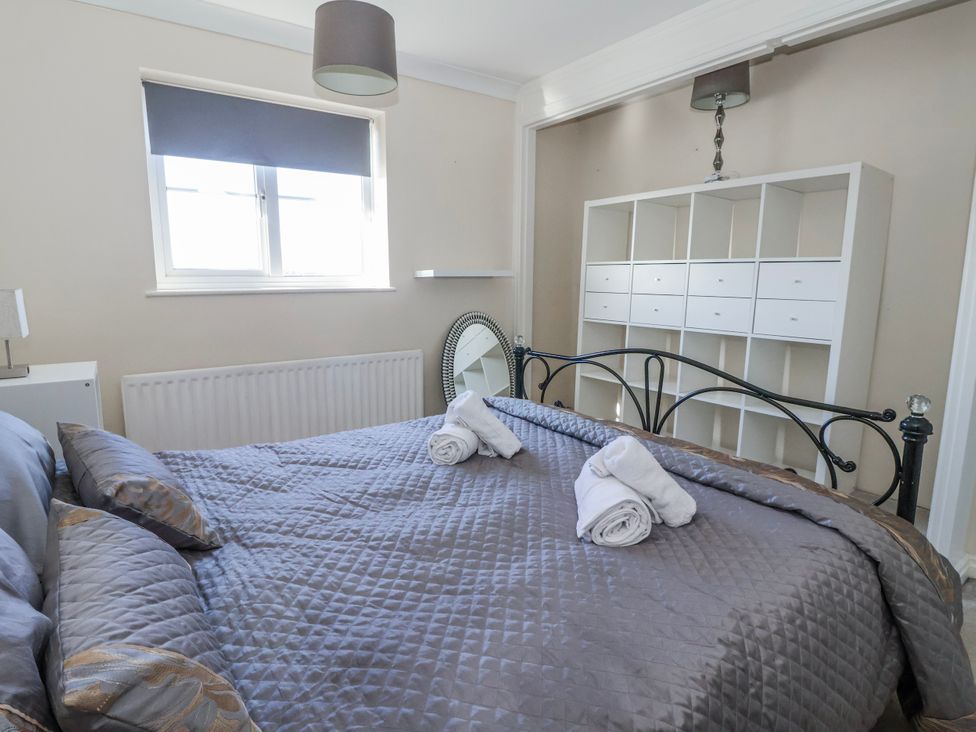 A bedroom with a bed and storage unit at Thorntons House in Morton-On-Swale