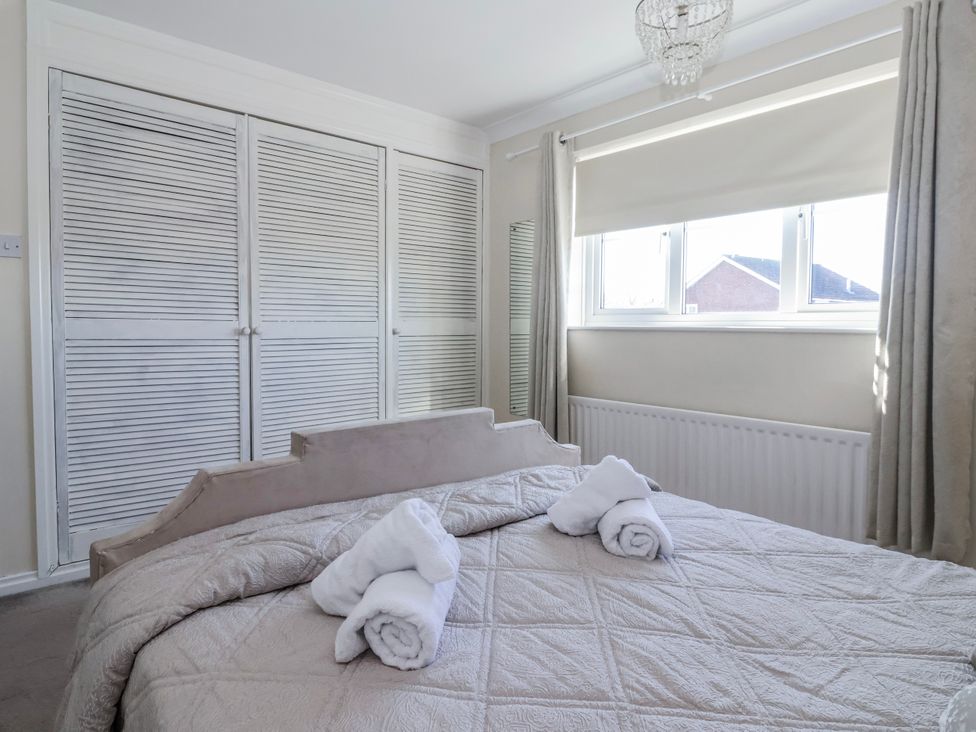 A bedroom with a bed and wardrobe at Thorntons House in Morton-On-Swale
