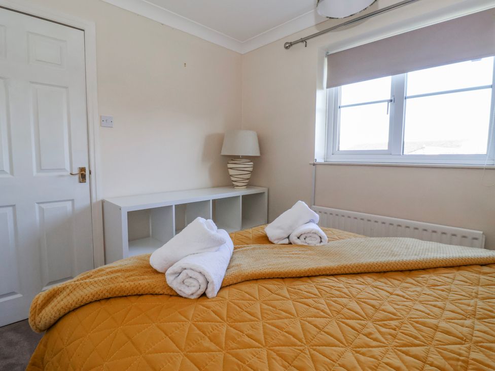 A bedroom with a bed and towels at Thorntons House in Morton-On-Swale