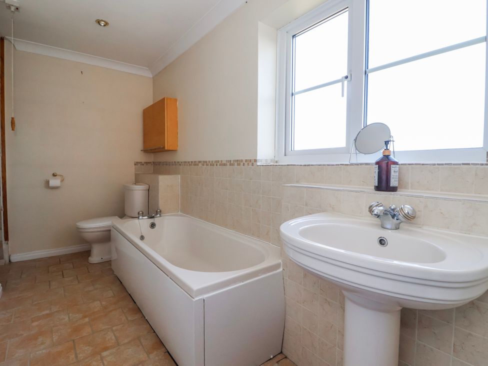 A bathroom with a bathtub, toilet, and sink at Thorntons House in Morton-On-Swale