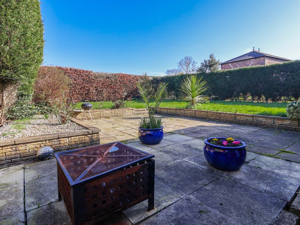 A garden with potted plants and a fire pit at Thorntons House in Morton-On-Swale