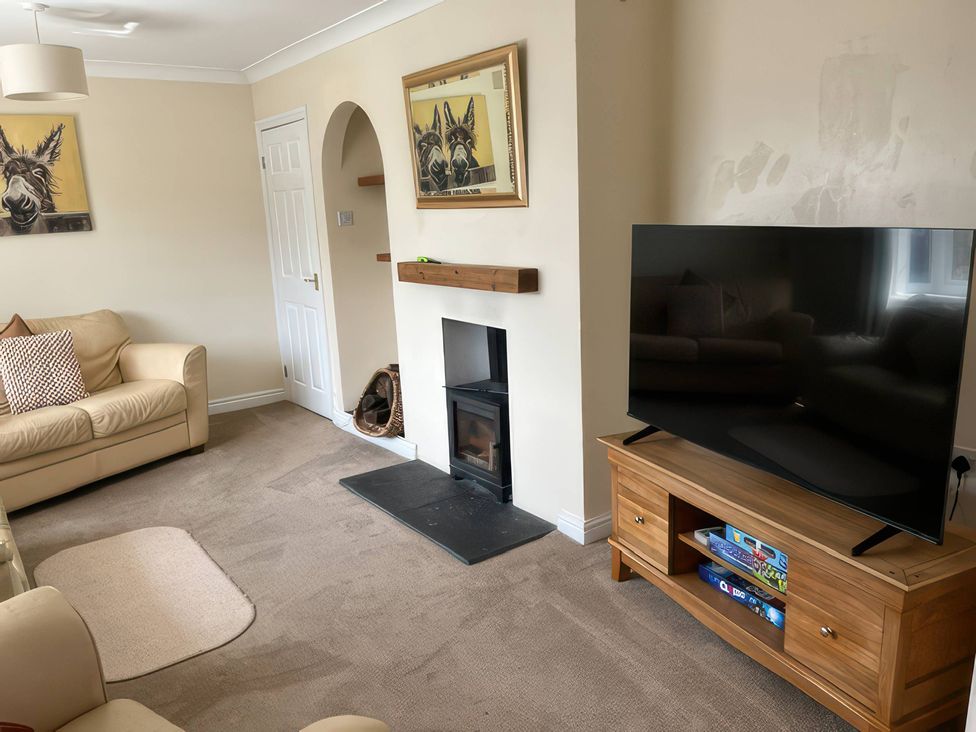 A living room with a sofa and television at Thorntons House in Morton-On-Swale
