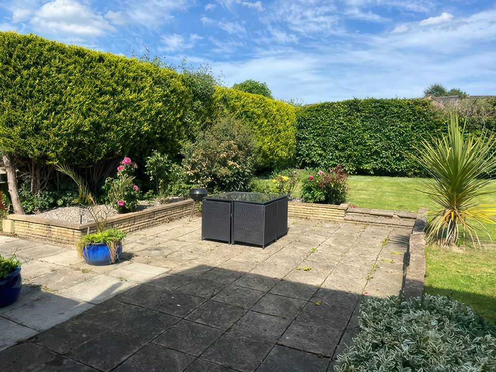 A garden with a patio and planters at Thorntons House in Morton-On-Swale