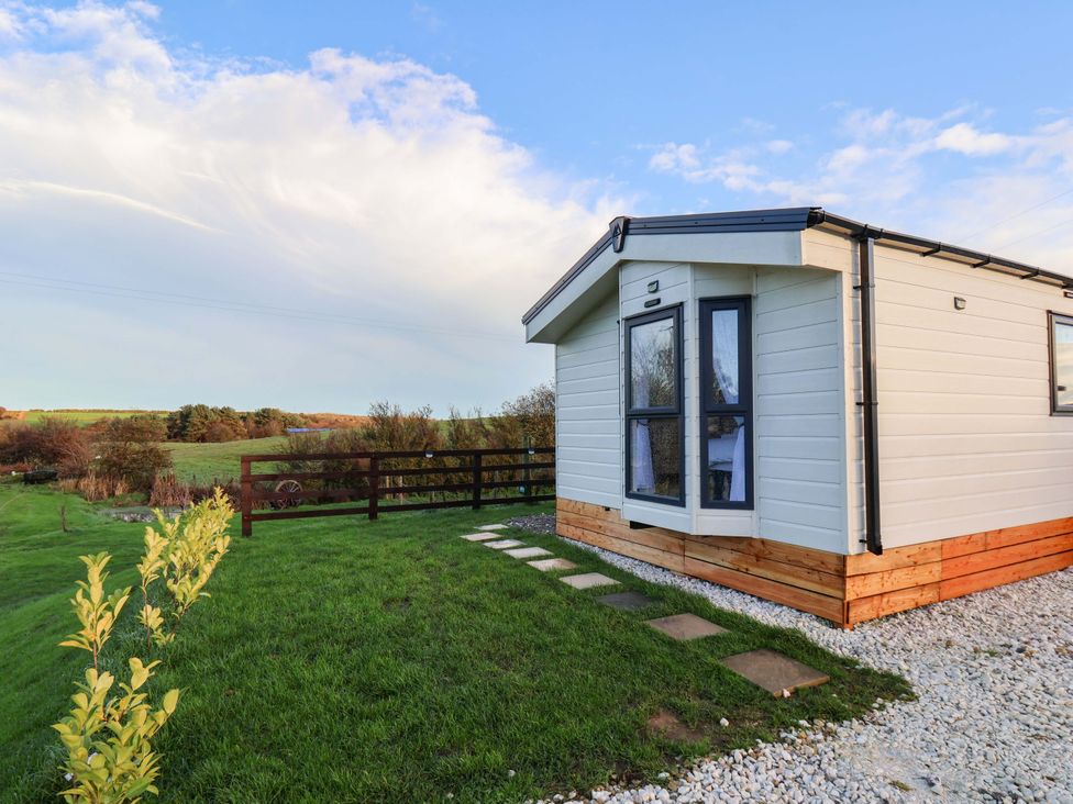 A cabin with a pathway and grass at Rosefinch Cabin in Scarborough