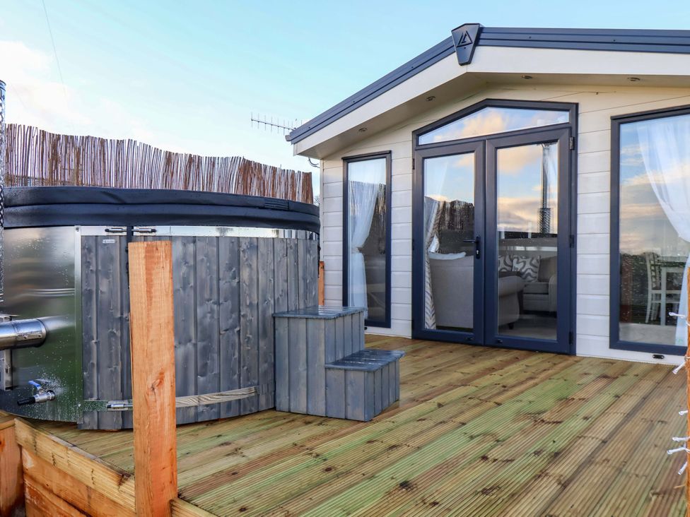 An outdoor area with a hot tub and steps at Rosefinch Cabin Scarborough