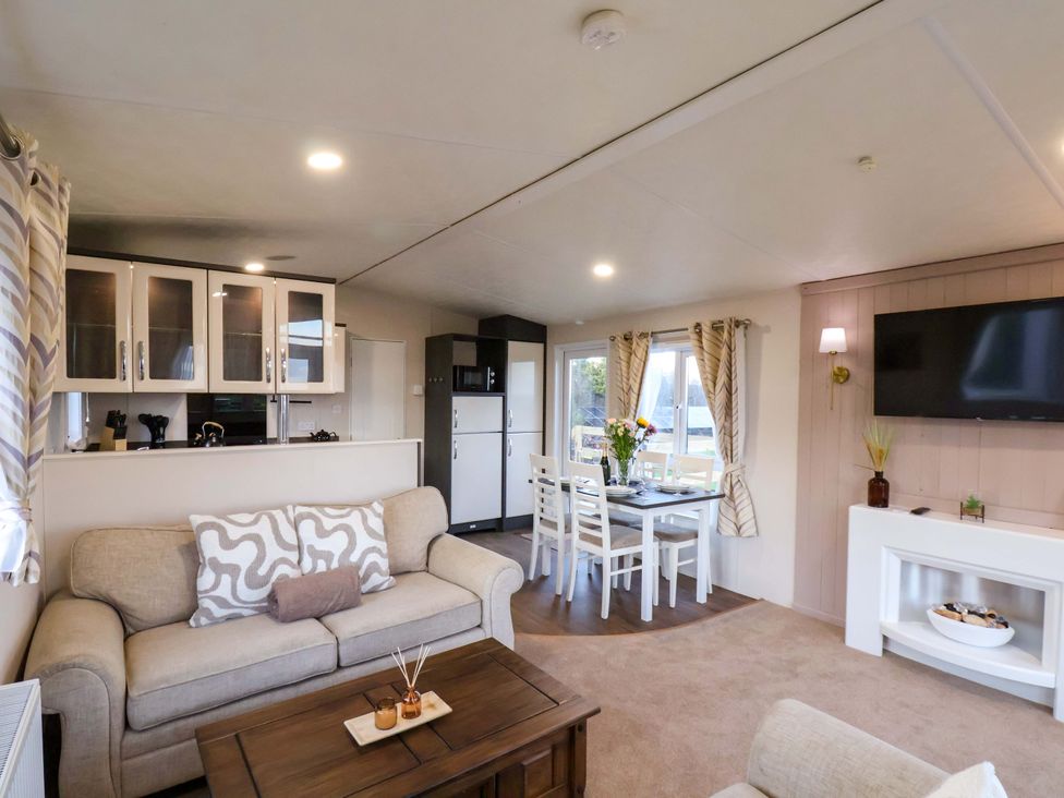 A living room with seating and a dining area at Rosefinch Cabin in Scarborough