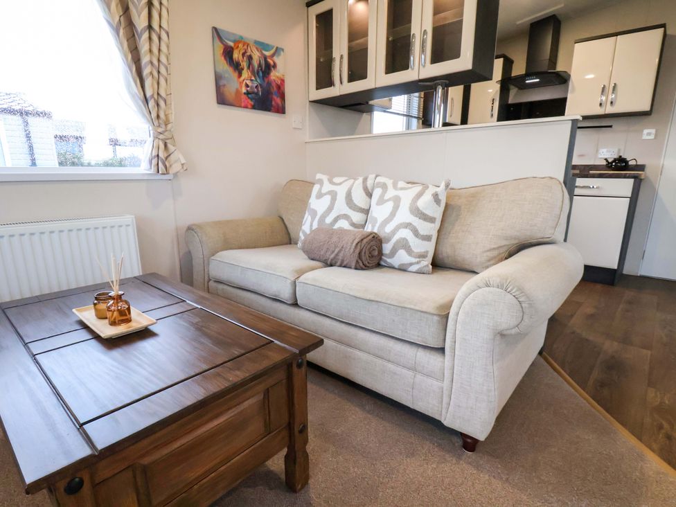A living room with a sofa and coffee table at Rosefinch Cabin Scarborough