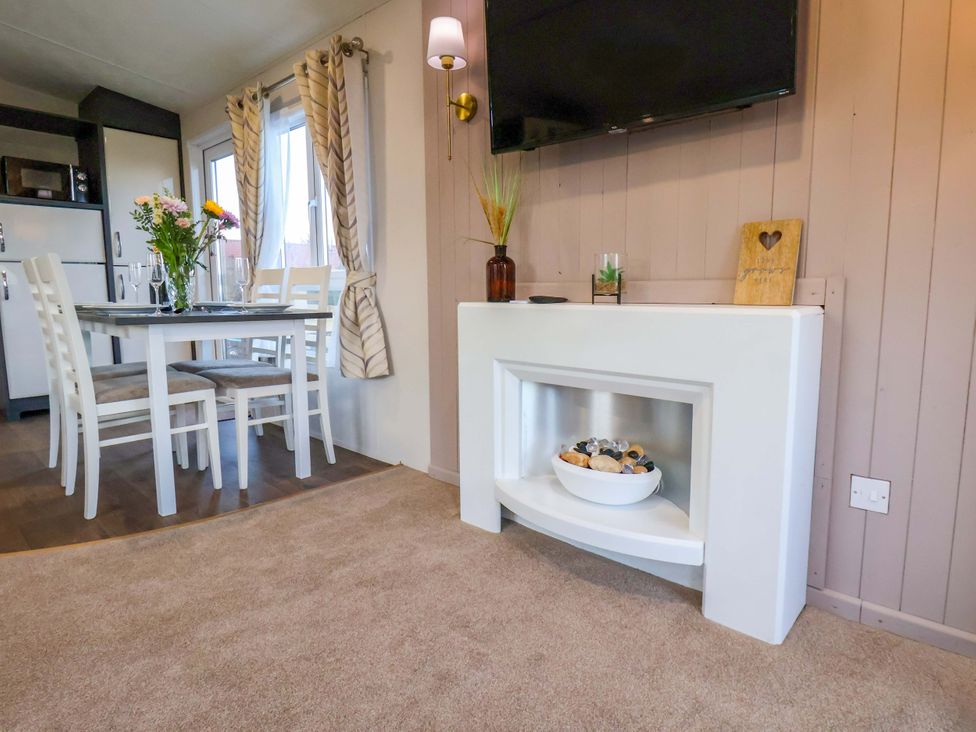 A dining room with a table and chairs at Rosefinch Cabin Scarborough
