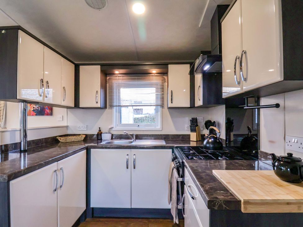 A kitchen with cabinets and a sink at Rosefinch Cabin in Scarborough