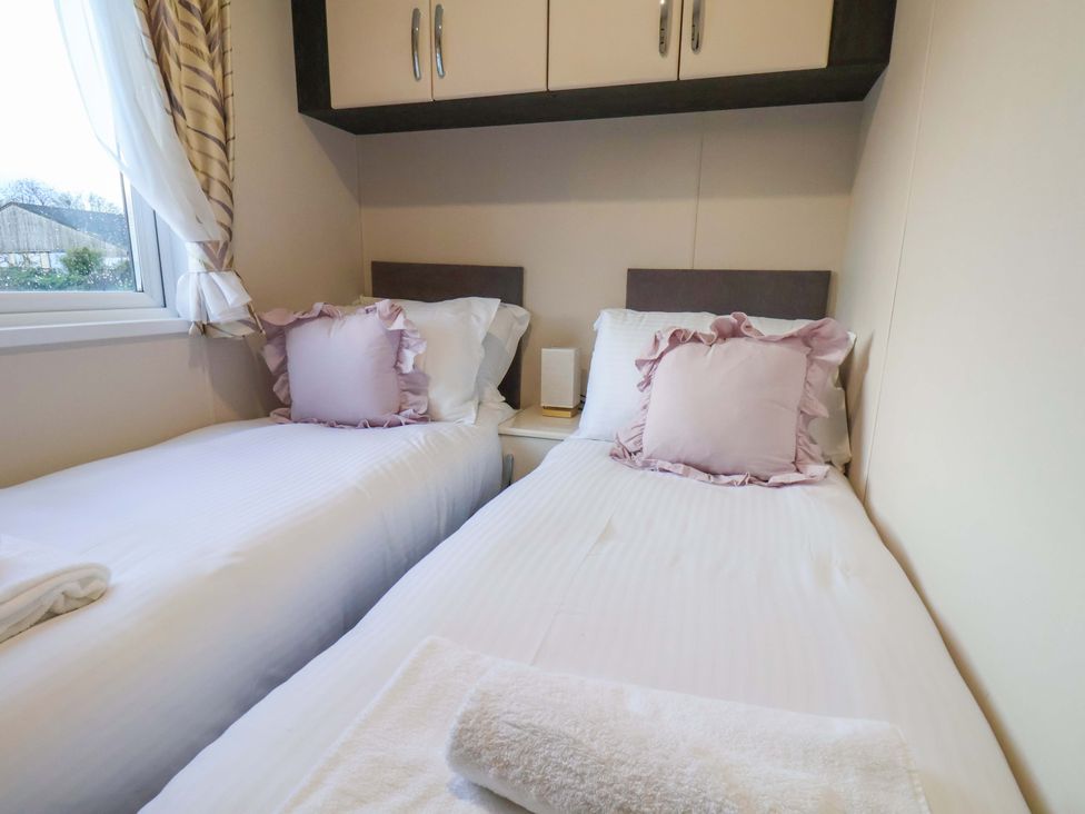 A bedroom with two beds and a window at Rosefinch Cabin Scarborough
