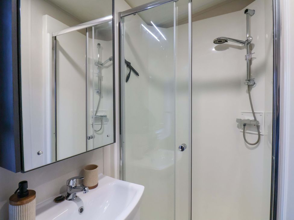 A bathroom with a shower and sink at Rosefinch Cabin Scarborough