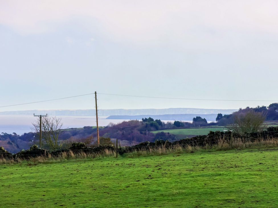 A view of the landscape with grass and sea at Rosefinch Cabin Scarborough