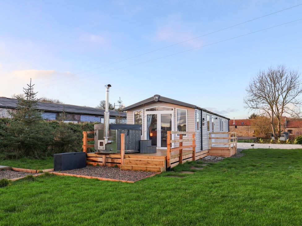 A cabin with a deck and stove at Swift Cabin Scarborough