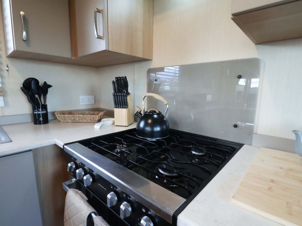 A kitchen with a stove and utensils at Swift Cabin in Scarborough