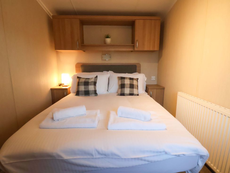 A bedroom with a bed and pillows at Swift Cabin in Scarborough