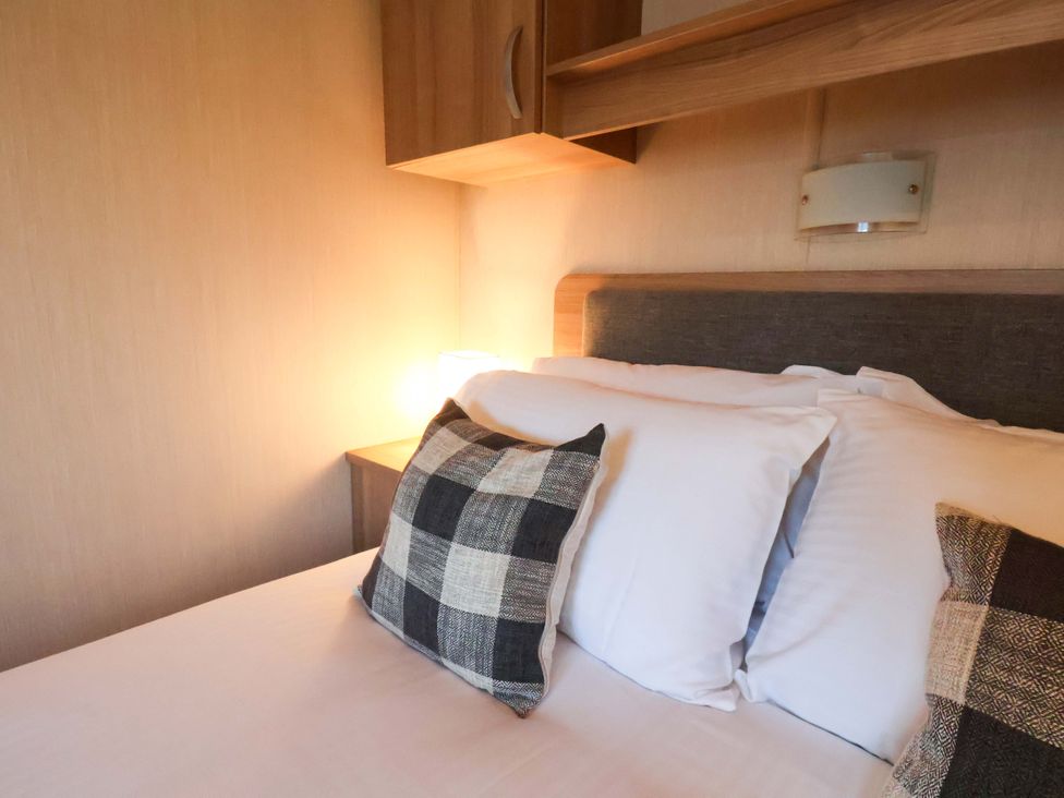 A bedroom with a bed and pillows at Swift Cabin Scarborough