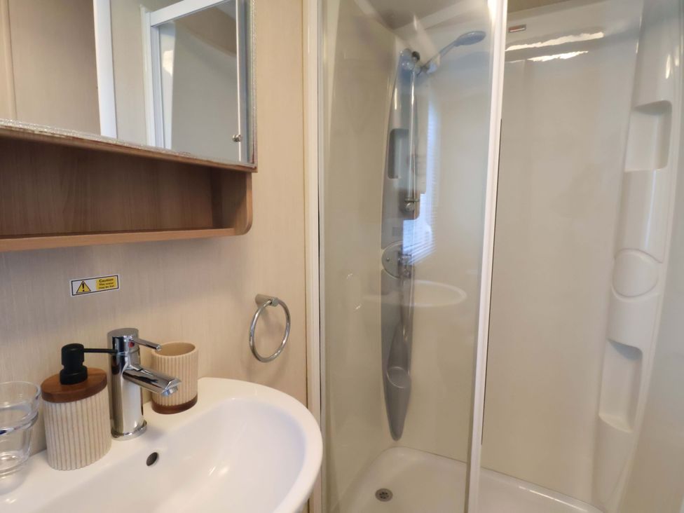 A bathroom with a sink and shower at Swift Cabin Scarborough