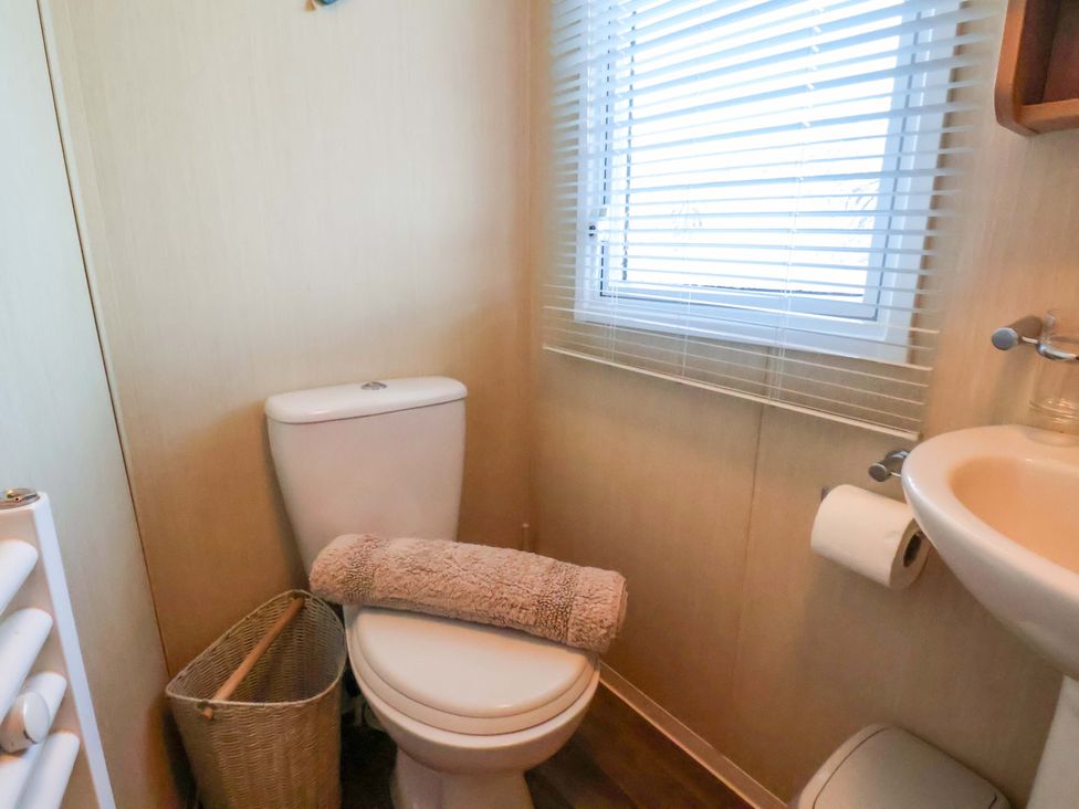 A bathroom with a toilet and sink at Swift Cabin Scarborough