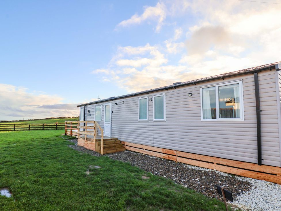 A cabin with wooden steps and windows at Swift Cabin in Scarborough