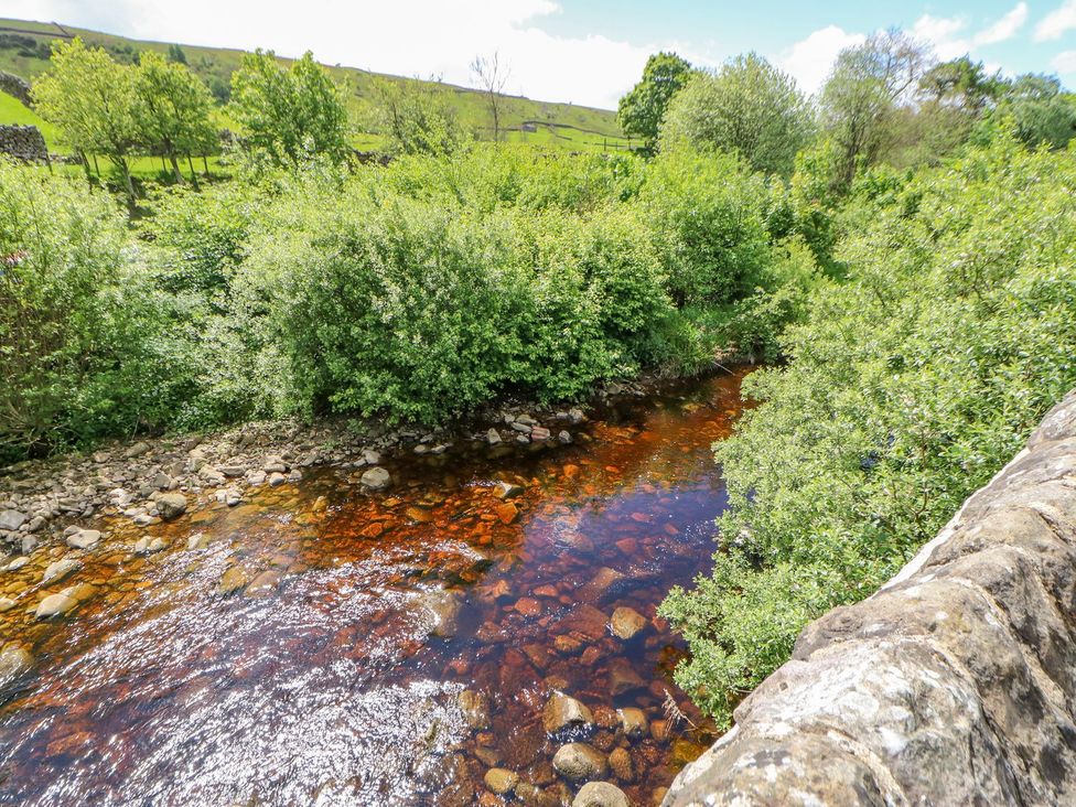 A stream with rocks and greenery at Wayside Farm in Richmond