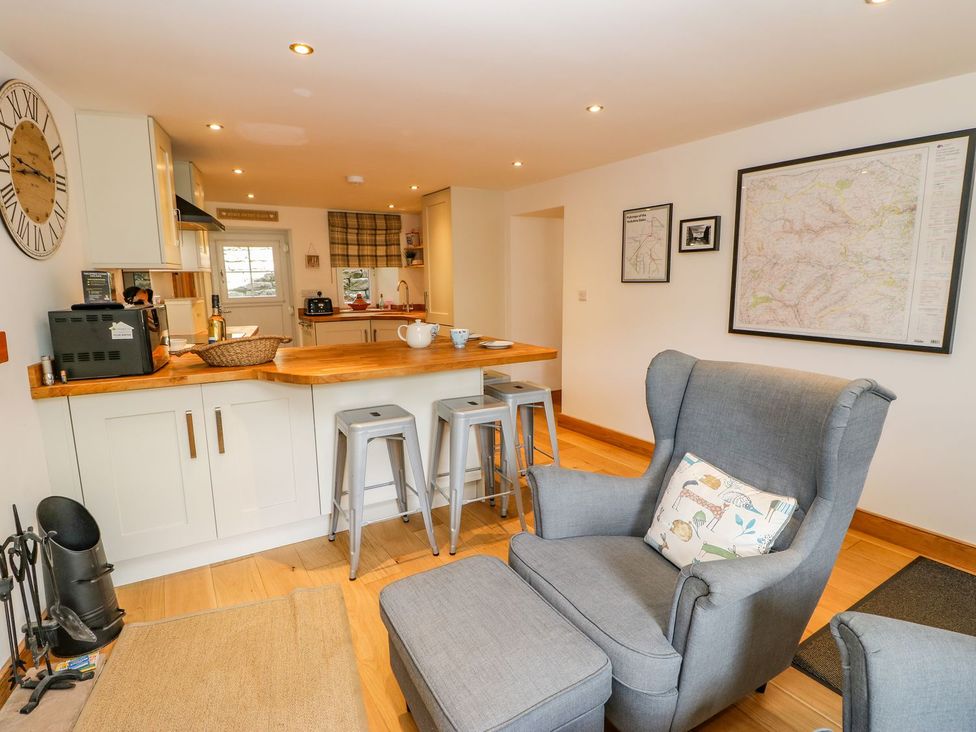 A kitchen with bar stools and an armchair at Wayside Farm in Richmond