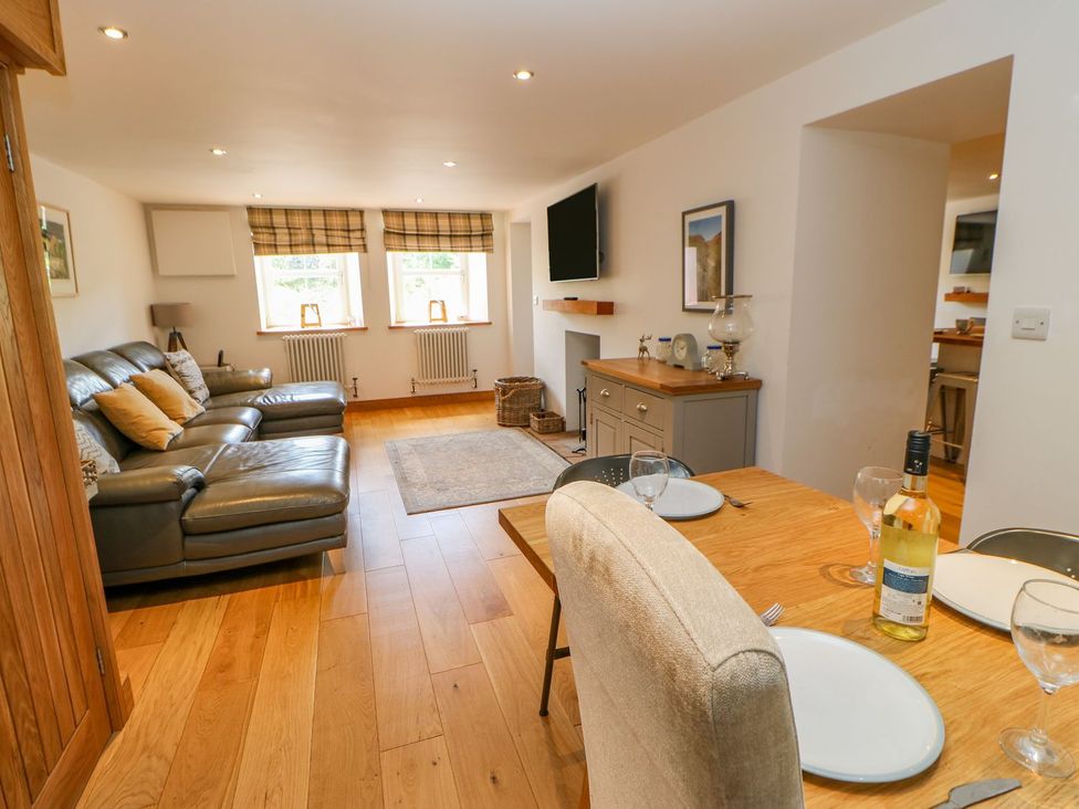 A living room with a sofa and dining area at Wayside Farm in Richmond
