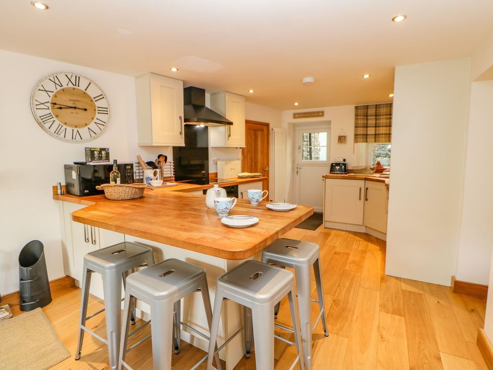 A kitchen with an island and stools at Wayside Farm in Richmond