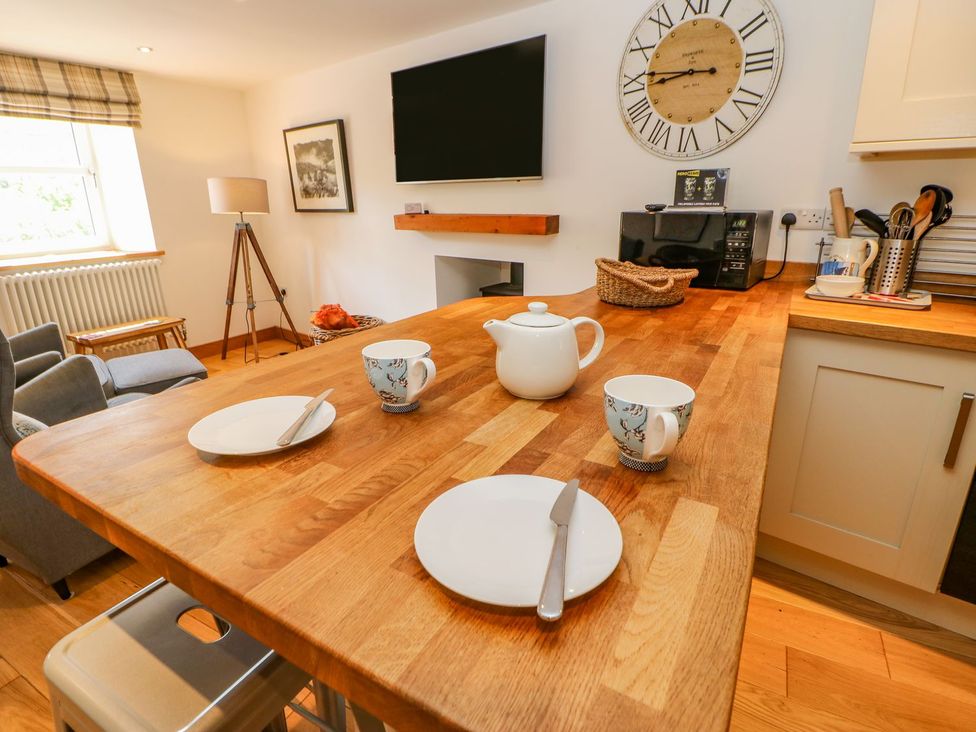 A kitchen with a wooden table set for tea at Wayside Farm Richmond